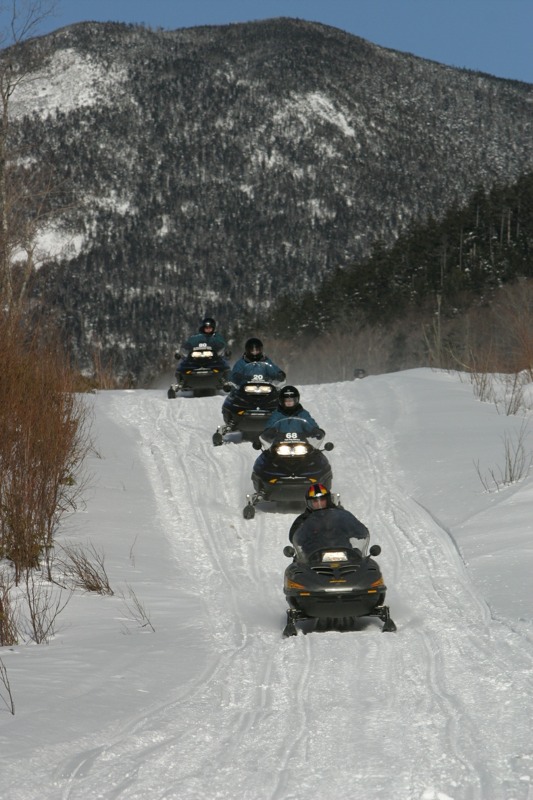Train of snowmobile riders